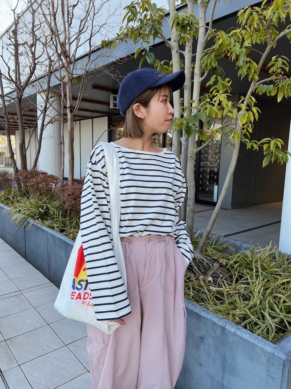 ピンク系のカーゴパンツ、ホワイト系のエコバッグ/サブバッグ、ブルー系のTシャツ/カットソーを着用したレディースの冬コーディネートの7枚目の写真