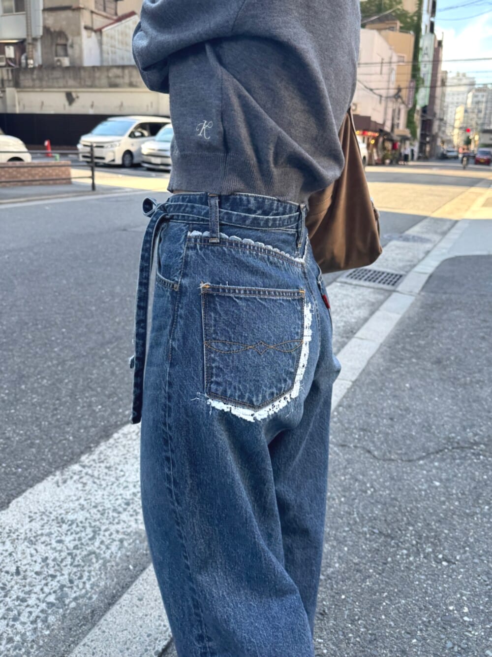 ベージュ系のスリッポン、グレー系のカーディガン/ボレロ、ブルー系のデニムパンツを着用したレディースの夏コーディネートの6枚目の写真