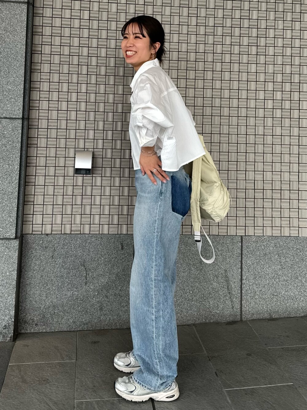 ブルー系のデニムパンツ、ホワイト系のシャツ/ブラウス、ブラック系のキャミソールを着用したレディースの春コーディネートの2枚目の写真