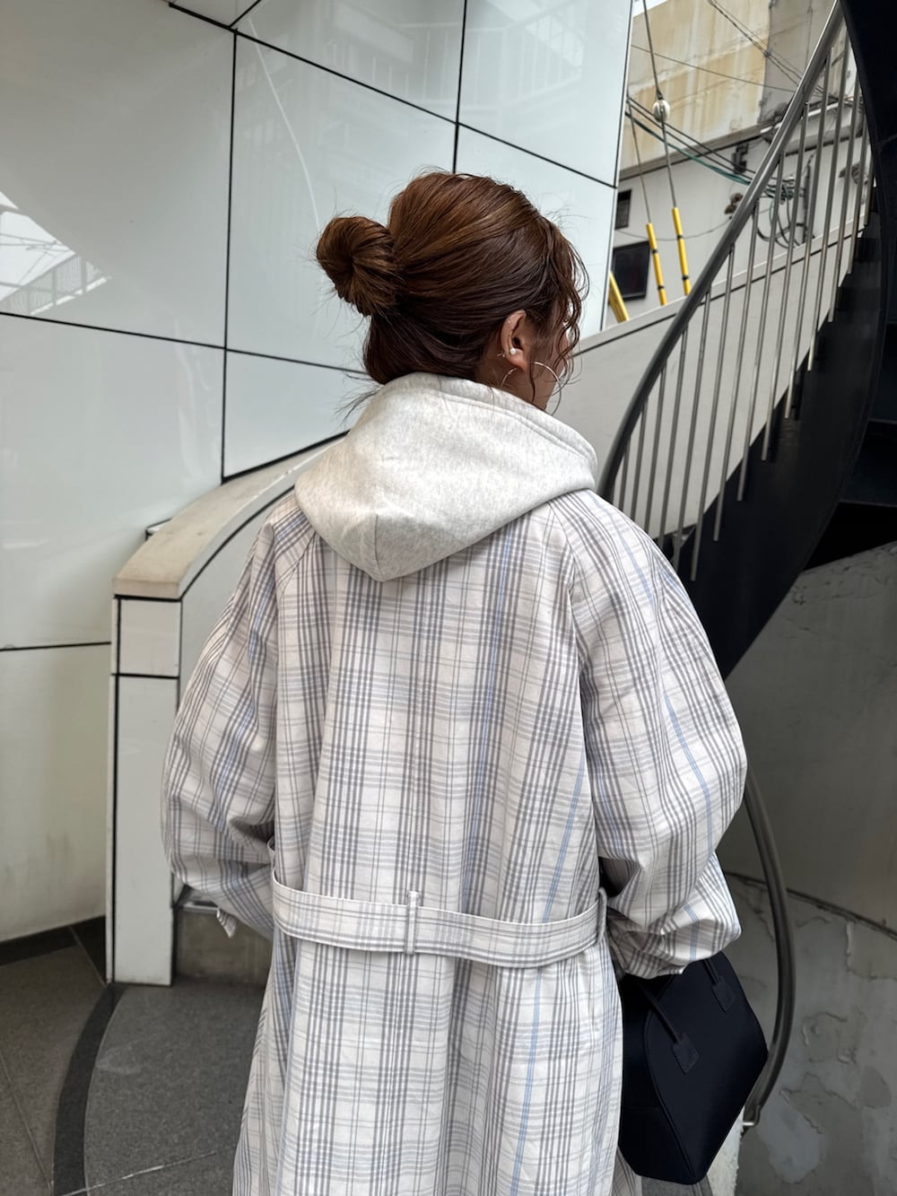 その他のステンカラーコート、ブラック系のボストンバッグ、ホワイト系のパーカーを着用したレディースの冬コーディネートの8枚目の写真