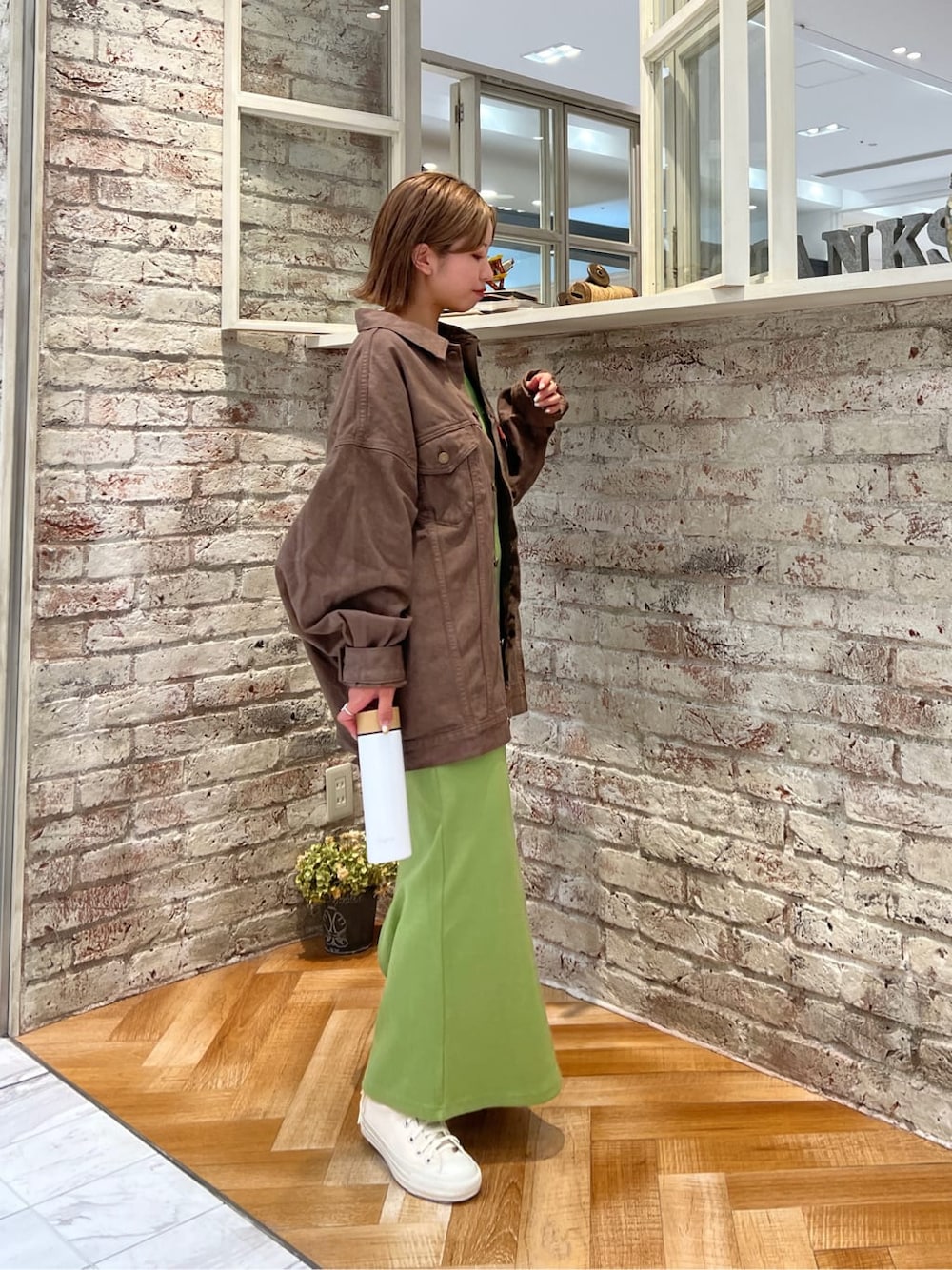 ブラウン系のデニムジャケット、グリーン系のワンピースを着用したレディースの夏コーディネートの4枚目の写真