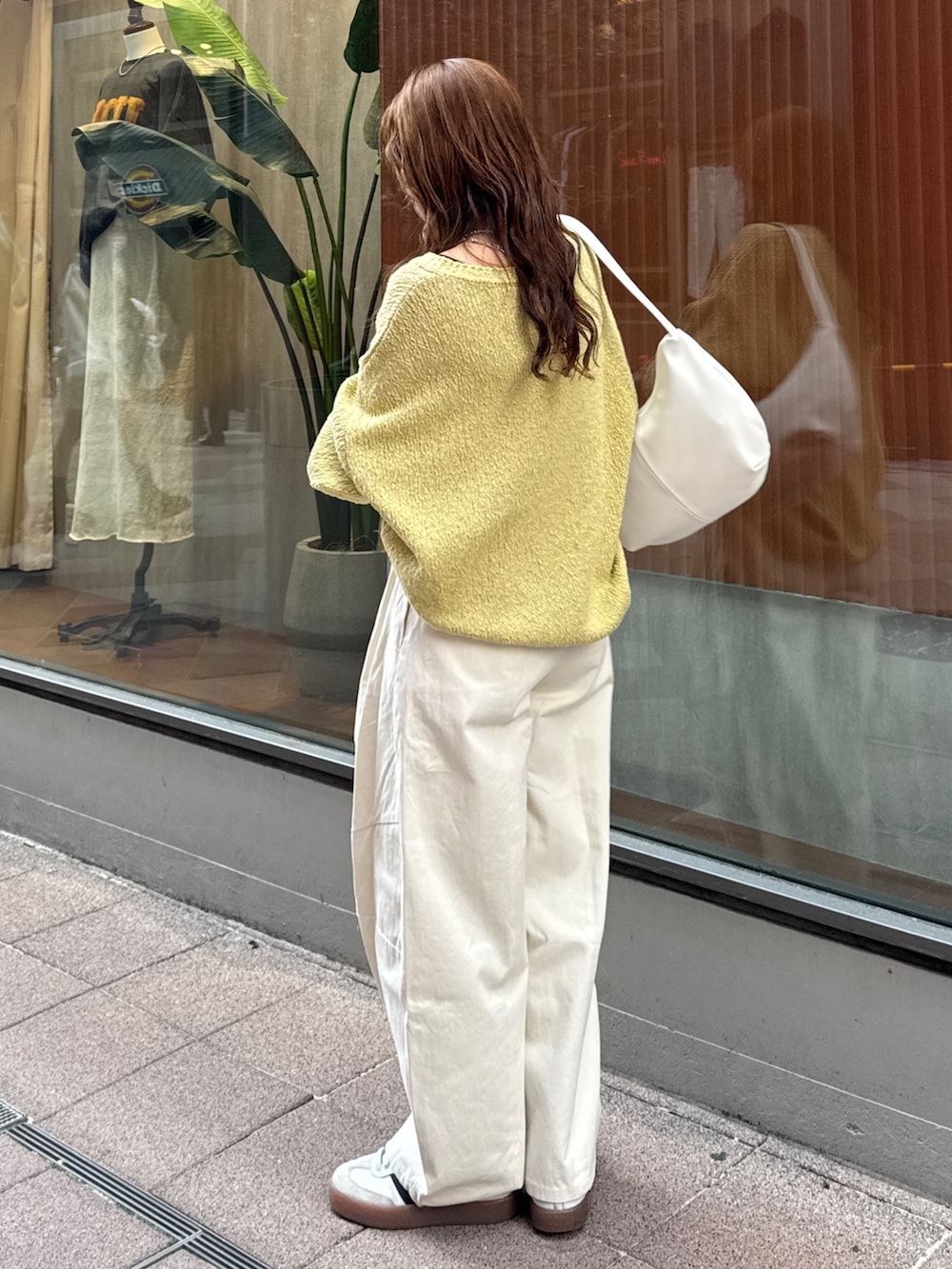 ホワイト系のチノパンツ、グリーン系のニット/セーター、ホワイト系のショルダーバッグを着用したレディースの冬コーディネートの3枚目の写真