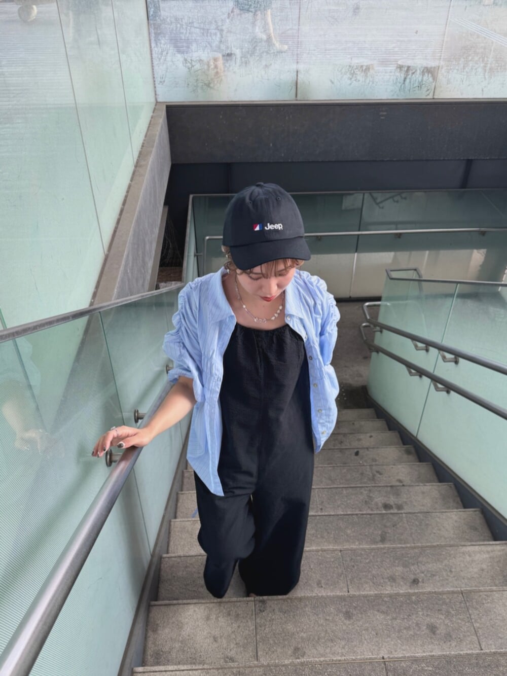 ブラック系のサンダル、ブラック系のサロペット/オーバーオール、ブルー系のシャツ/ブラウスを着用したレディースの夏コーディネートの7枚目の写真