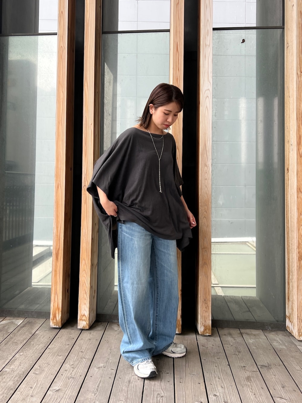 グレー系のTシャツ/カットソー、ブルー系のデニムパンツ、シルバー系のネックレスを着用したレディースの春コーディネートの5枚目の写真