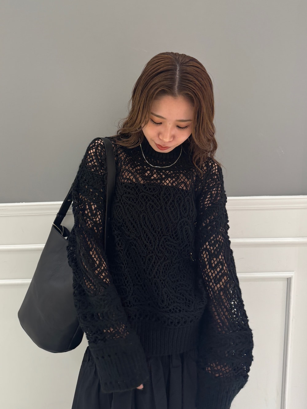 ブラック系のスカート、ブラック系のニット/セーター、ブラック系のショルダーバッグを着用したレディースの冬コーディネートの8枚目の写真