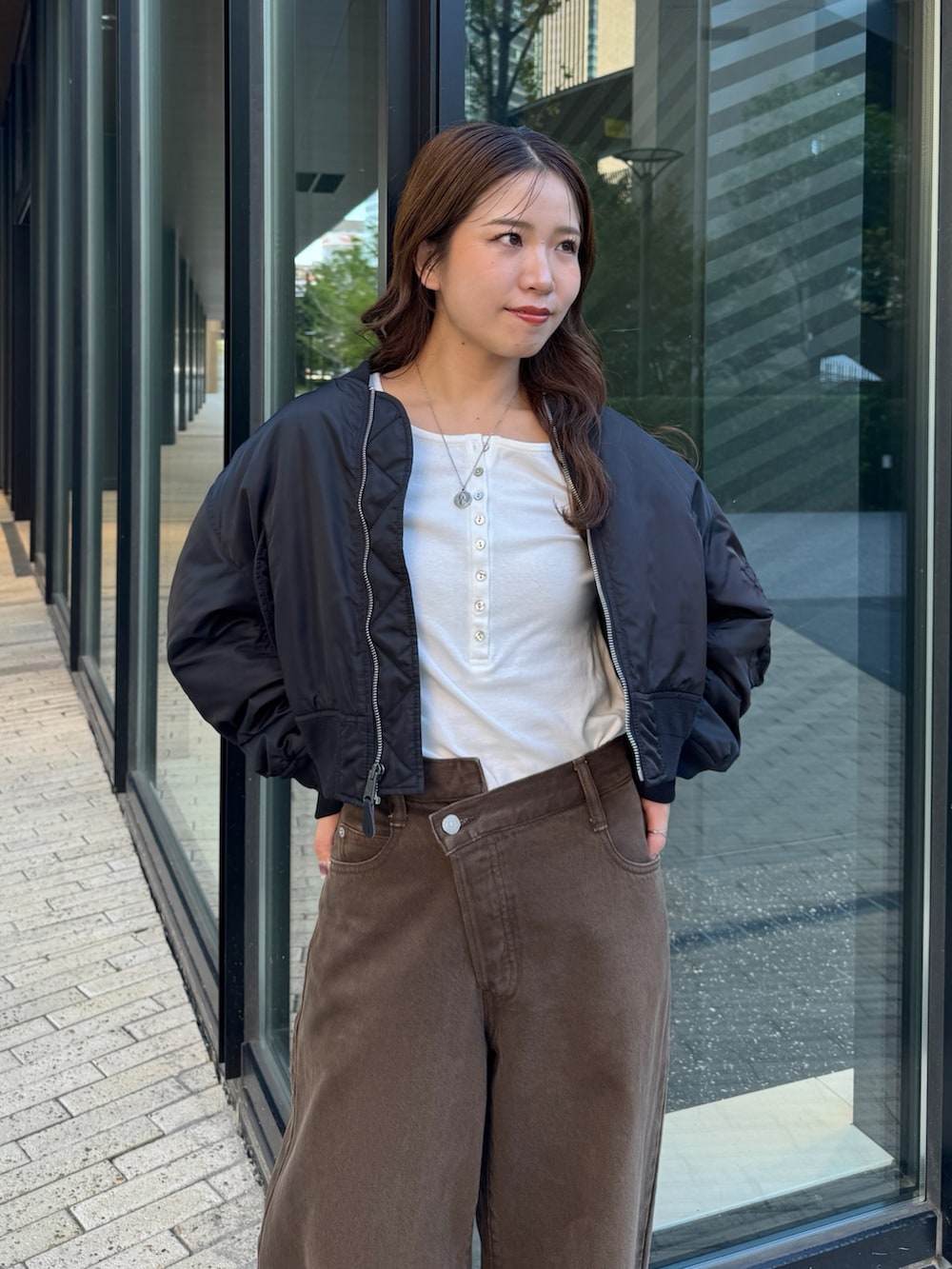 ブラウン系のデニムパンツ、ホワイト系のTシャツ/カットソー、ブラック系のMA-1を着用したレディースの秋コーディネートの7枚目の写真