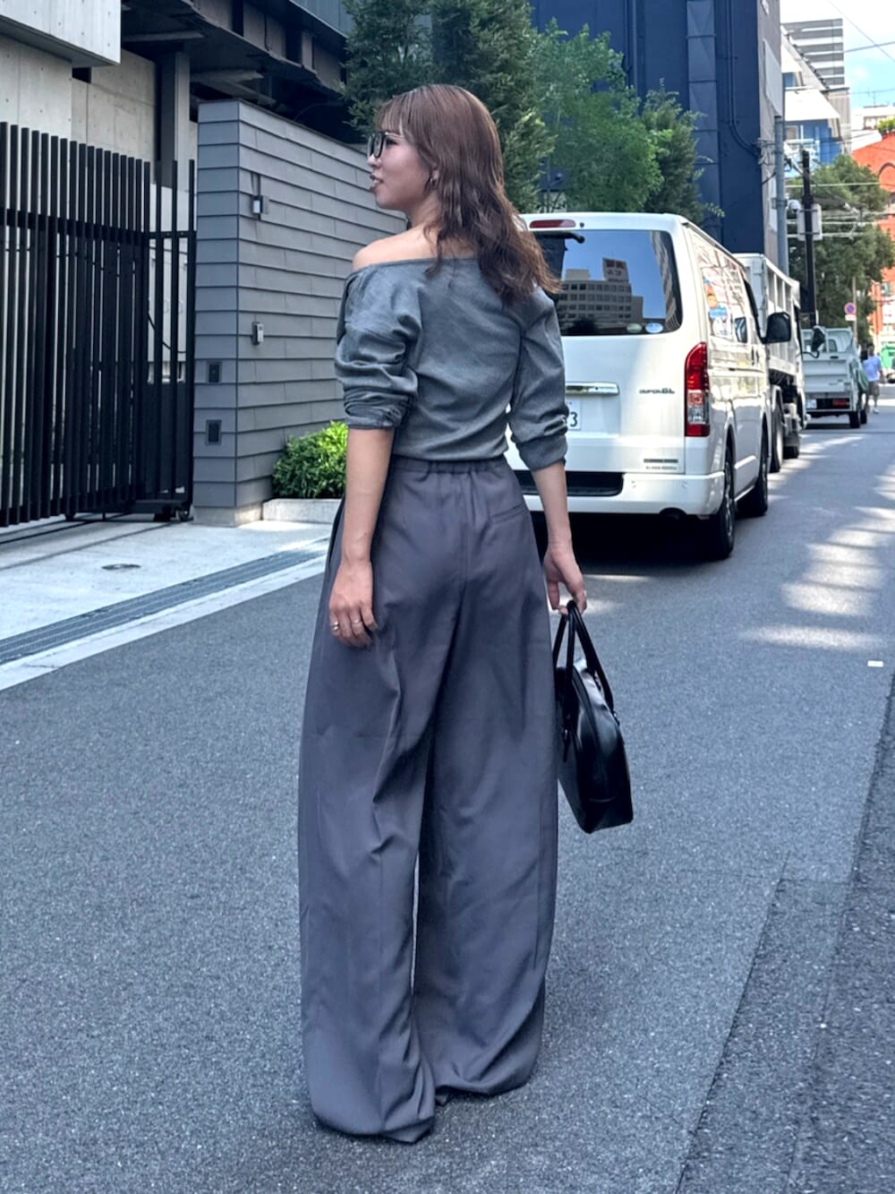 グレー系のその他パンツ、ベージュ系のスリッポン、ブラック系のハンドバッグを着用したレディースの夏コーディネートの4枚目の写真