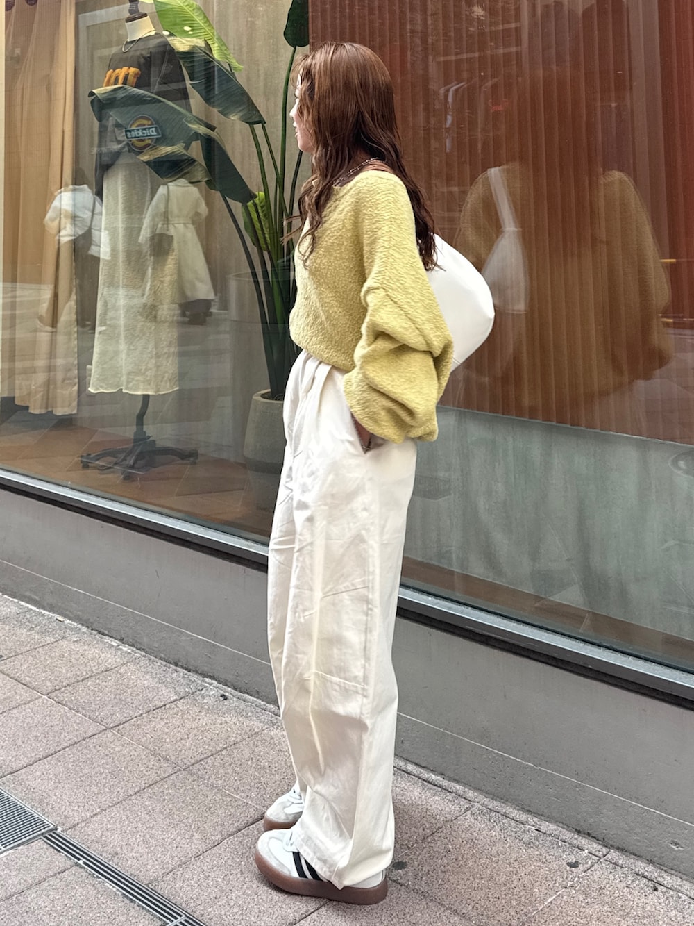 ホワイト系のチノパンツ、グリーン系のニット/セーター、ホワイト系のショルダーバッグを着用したレディースの冬コーディネートの4枚目の写真