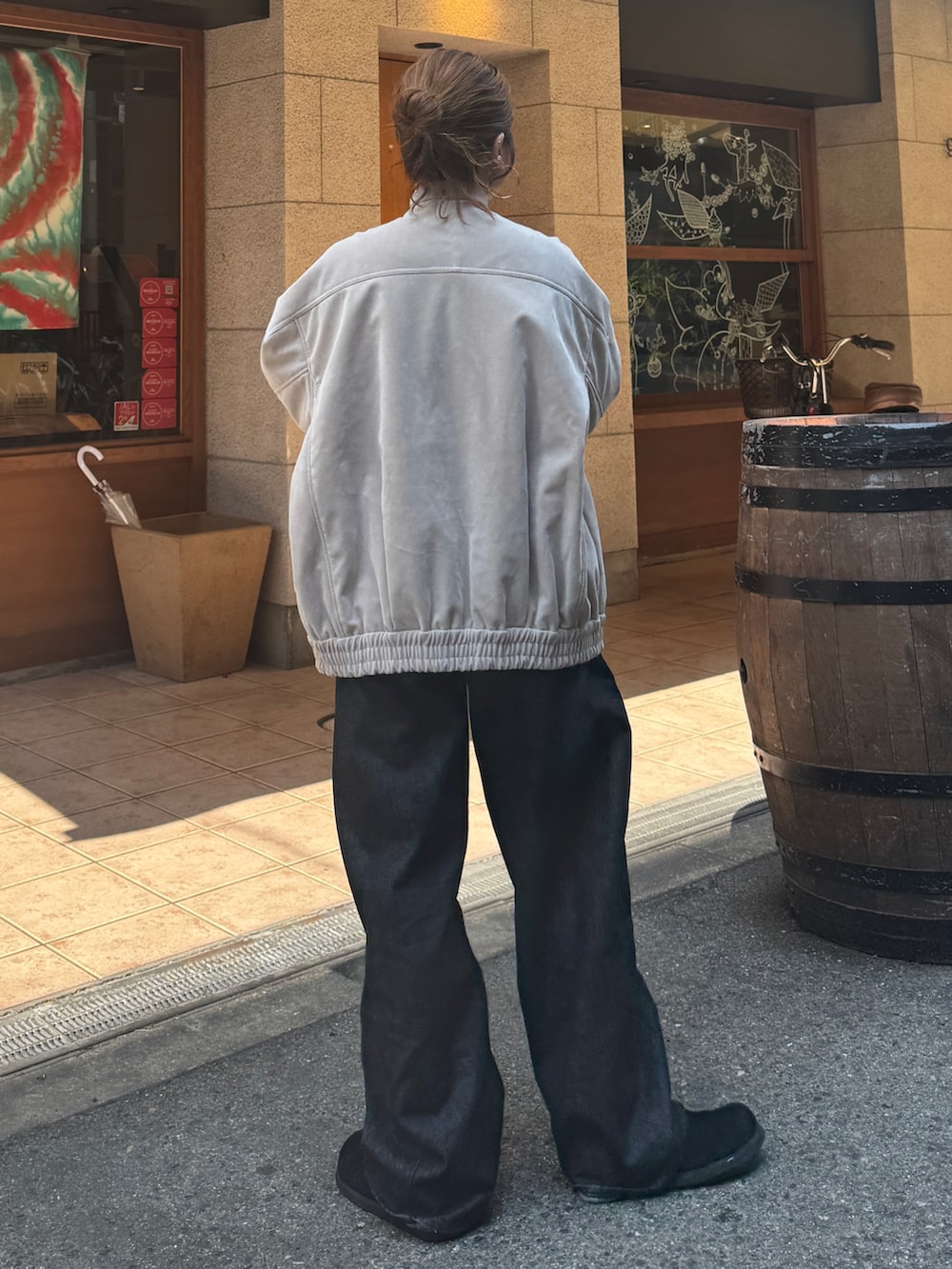 ベージュ系のブルゾン、ブラック系のデニムパンツ、ブラック系のスリッポンを着用したレディースの秋コーディネートの3枚目の写真