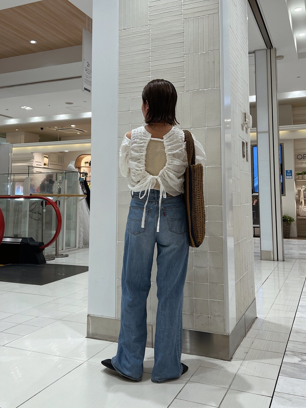 ホワイト系のシャツ/ブラウス、ブラウン系のトートバッグ、ブルー系のデニムパンツを着用したレディースの冬コーディネートの5枚目の写真