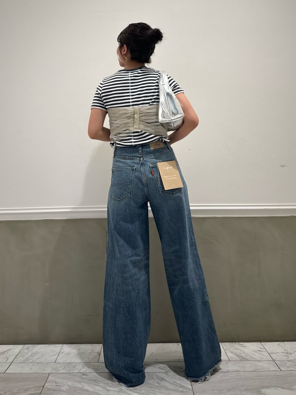 グレー系のTシャツ/カットソー、ベージュ系のキャミソール、ブルー系のデニムパンツを着用したレディースの春コーディネートの9枚目の写真