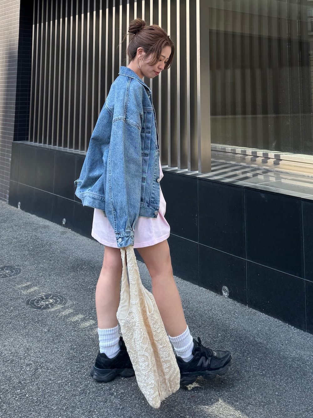 ピンク系のTシャツ/カットソー、ブルー系のデニムジャケット、ブラック系のその他パンツを着用したレディースの春コーディネートの3枚目の写真