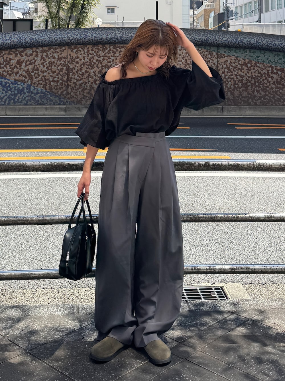 ブラック系のハンドバッグ、ベージュ系のスリッポン、グレー系のその他パンツを着用したレディースの夏コーディネートの2枚目の写真