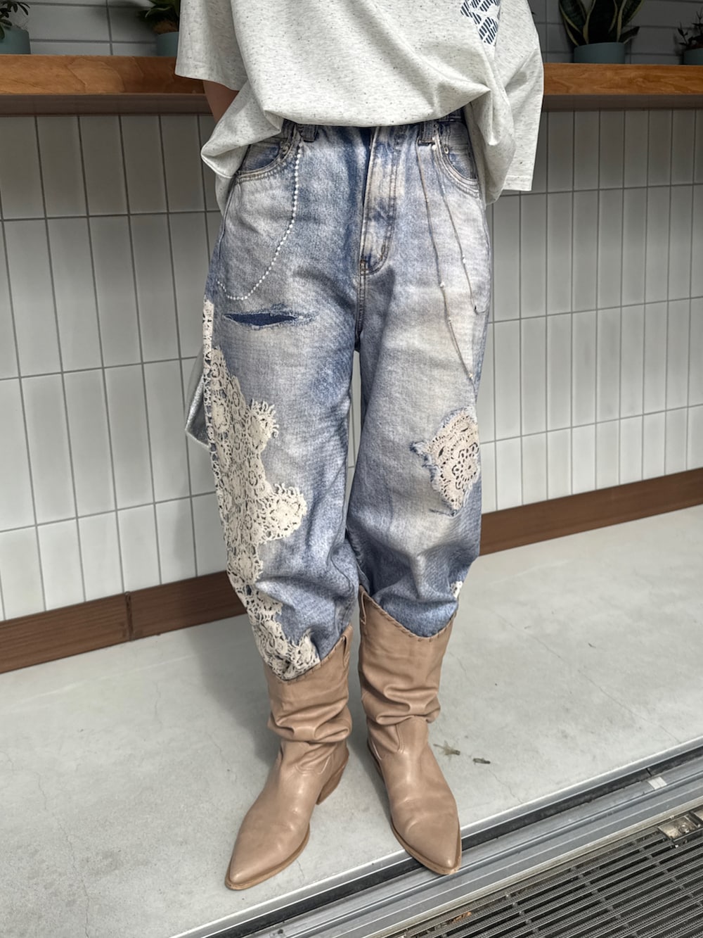 グレー系のTシャツ/カットソー、ブルー系のデニムパンツ、ベージュ系のブーツを着用したレディースの春コーディネートの10枚目の写真
