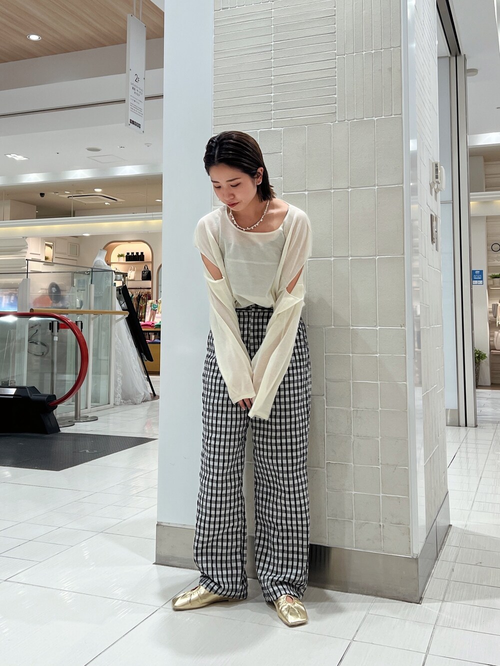 イエロー系のニット/セーター、イエロー系のパンプス、グレー系のその他パンツを着用したレディースの冬コーディネートの6枚目の写真