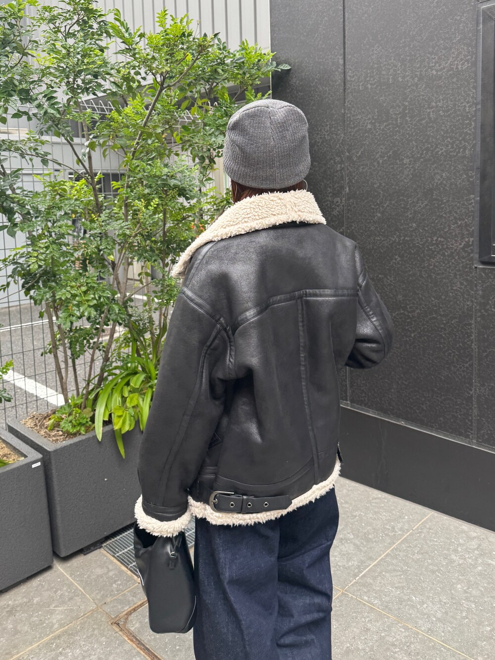 ブラック系のブルゾン、ブルー系のデニムパンツ、グレー系のニット/セーターを着用したレディースの秋コーディネートの10枚目の写真