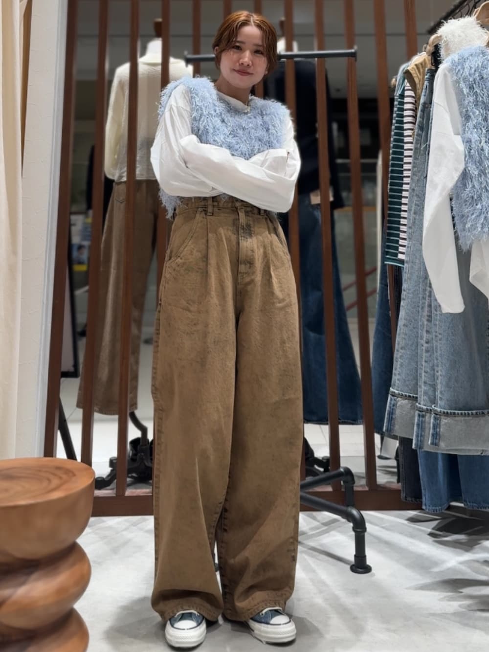 ブラウン系のデニムパンツ、ブルー系のニット/セーター、ホワイト系のTシャツ/カットソーを着用したレディースの春コーディネートの7枚目の写真