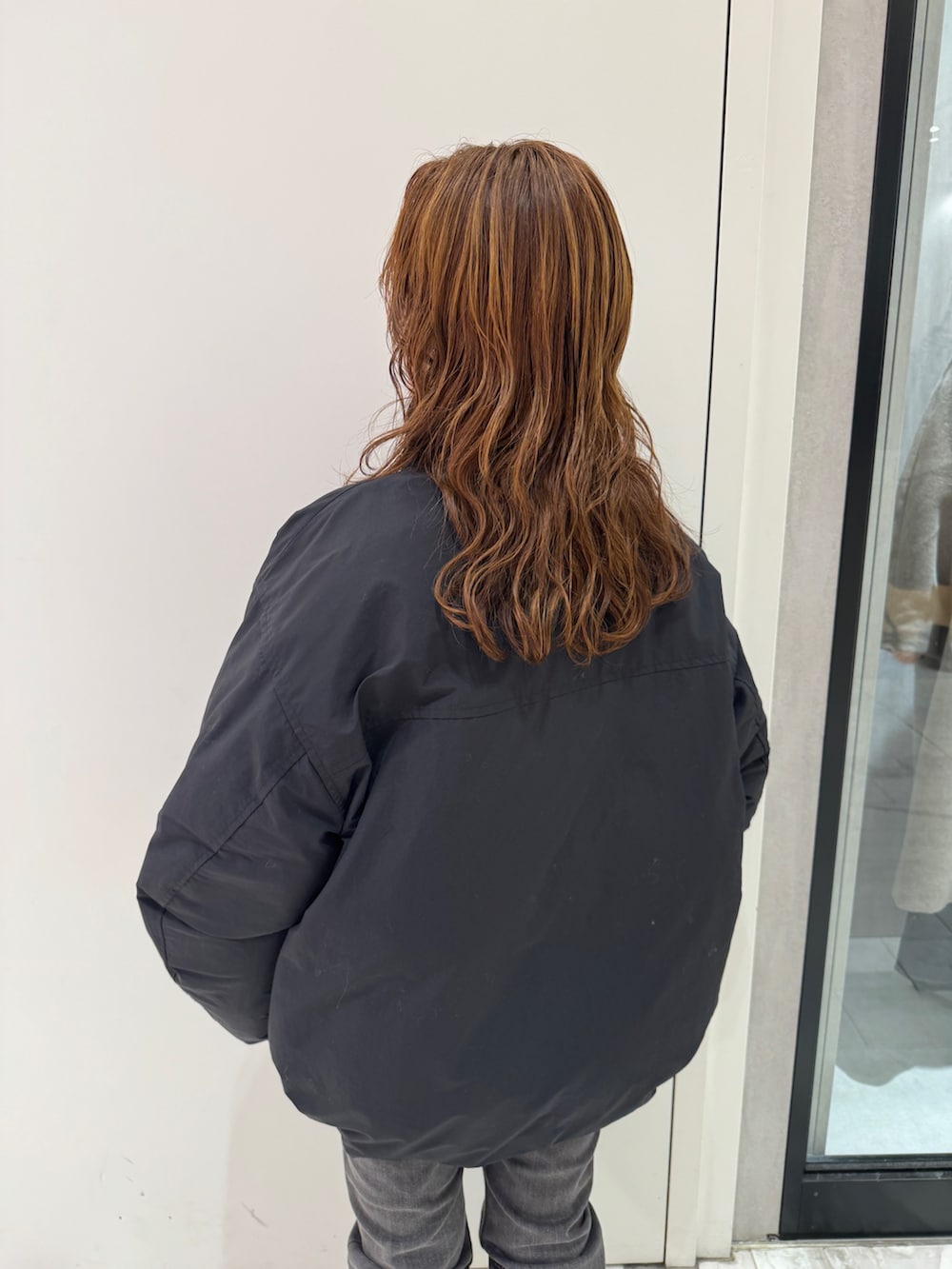 ブラック系のブルゾン、グレー系のスウェット、ブラック系のデニムパンツを着用したレディースの冬コーディネートの8枚目の写真