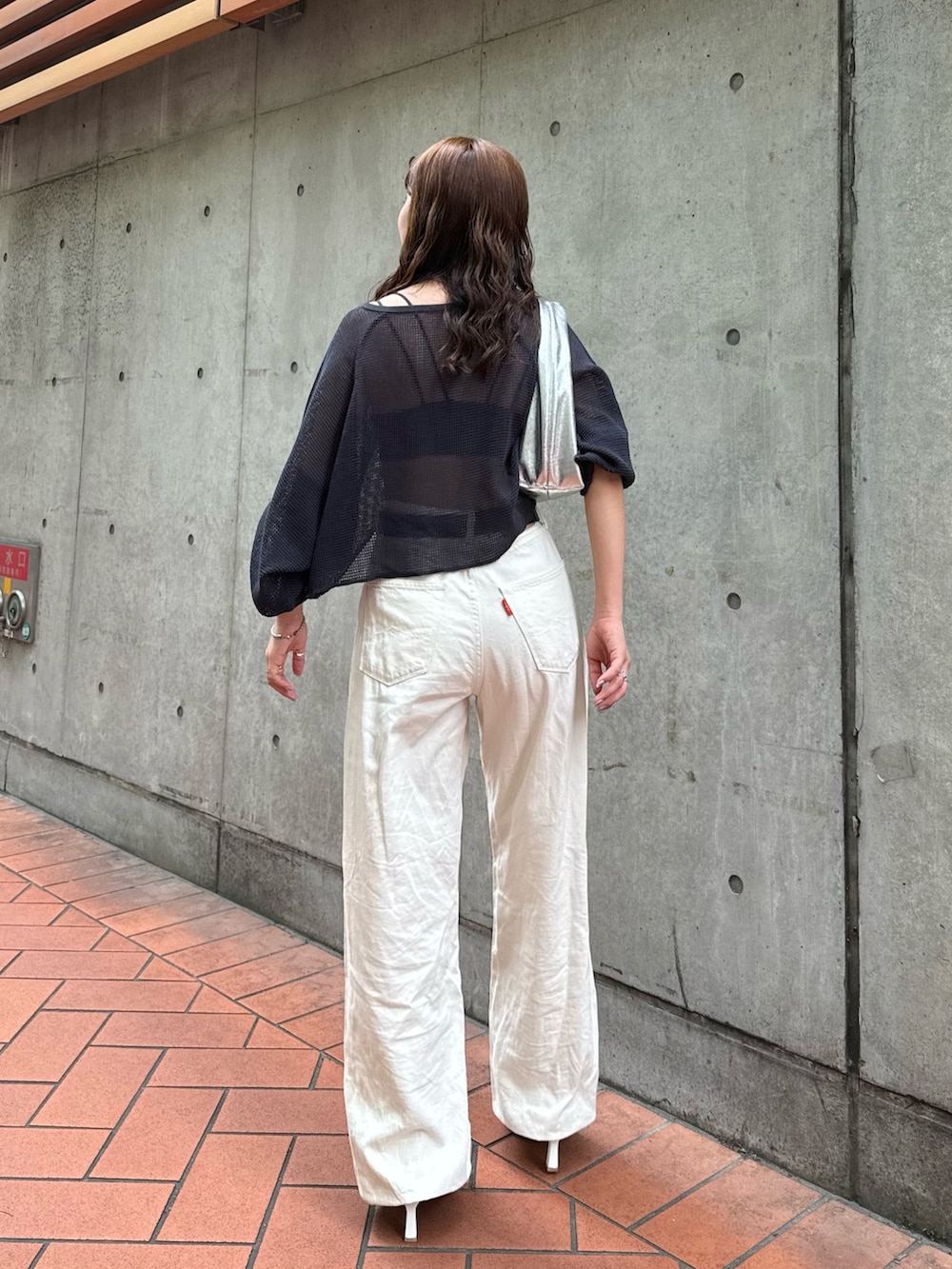 シルバー系のハンドバッグ、ホワイト系のデニムパンツ、グレー系のTシャツ/カットソーを着用したレディースの夏コーディネートの5枚目の写真