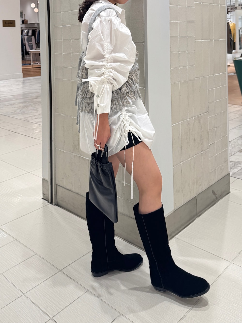 ホワイト系のシャツ/ブラウス、ブルー系のニット/セーター、ブラック系のショルダーバッグを着用したレディースの秋コーディネートの4枚目の写真