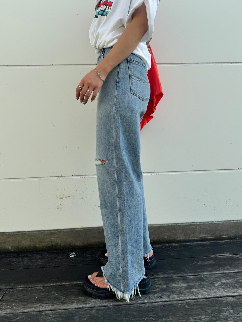 ブルー系のデニムパンツ、ホワイト系のTシャツ/カットソー、オレンジ系のエコバッグ/サブバッグを着用したレディースの夏コーディネートの7枚目の写真