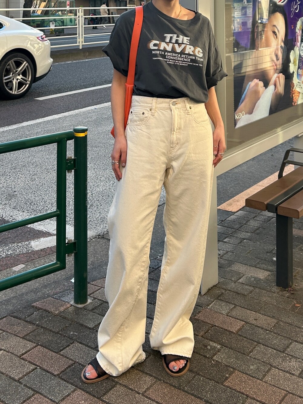 グレー系のTシャツ/カットソー、ホワイト系のデニムパンツ、オレンジ系のショルダーバッグを着用したレディースの春コーディネートの2枚目の写真