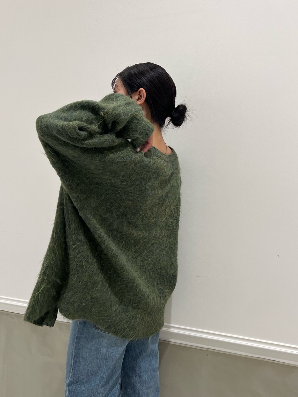 ブルー系のデニムパンツ、グリーン系のカーディガン/ボレロを着用したレディースの秋コーディネートの8枚目の写真
