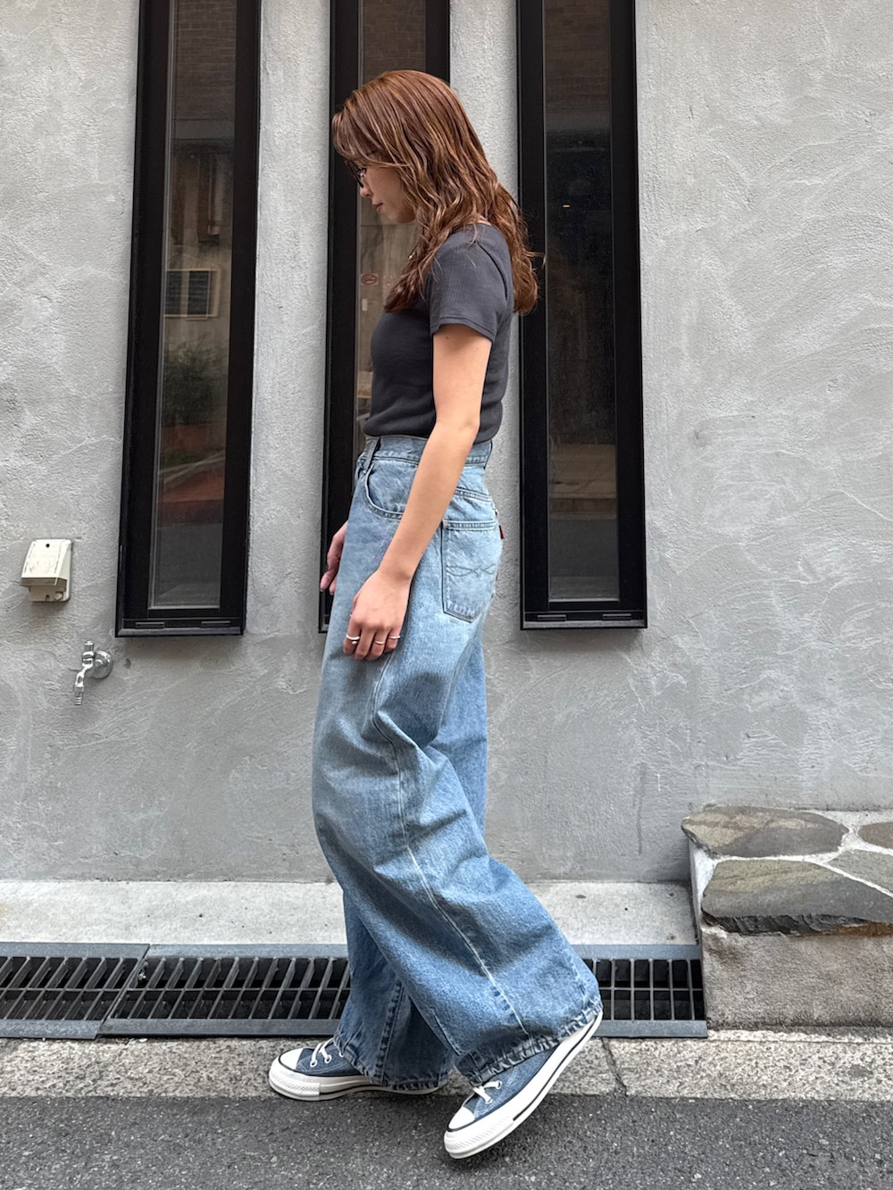 ブルー系のデニムパンツ、ブルー系のスニーカー、グレー系のTシャツ/カットソーを着用したレディースの春コーディネートの9枚目の写真