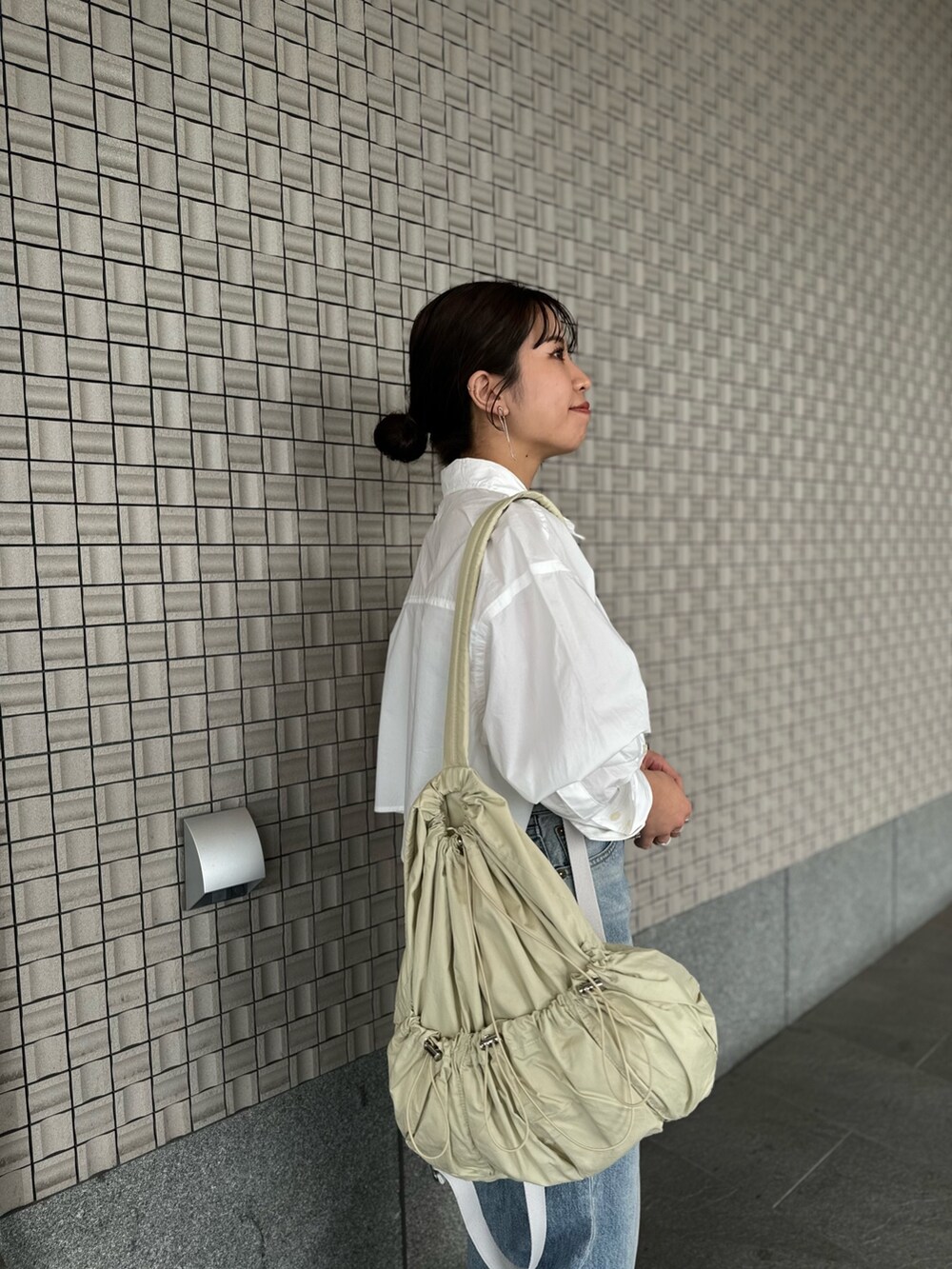 ブルー系のデニムパンツ、ホワイト系のシャツ/ブラウス、ブラック系のキャミソールを着用したレディースの春コーディネートの7枚目の写真