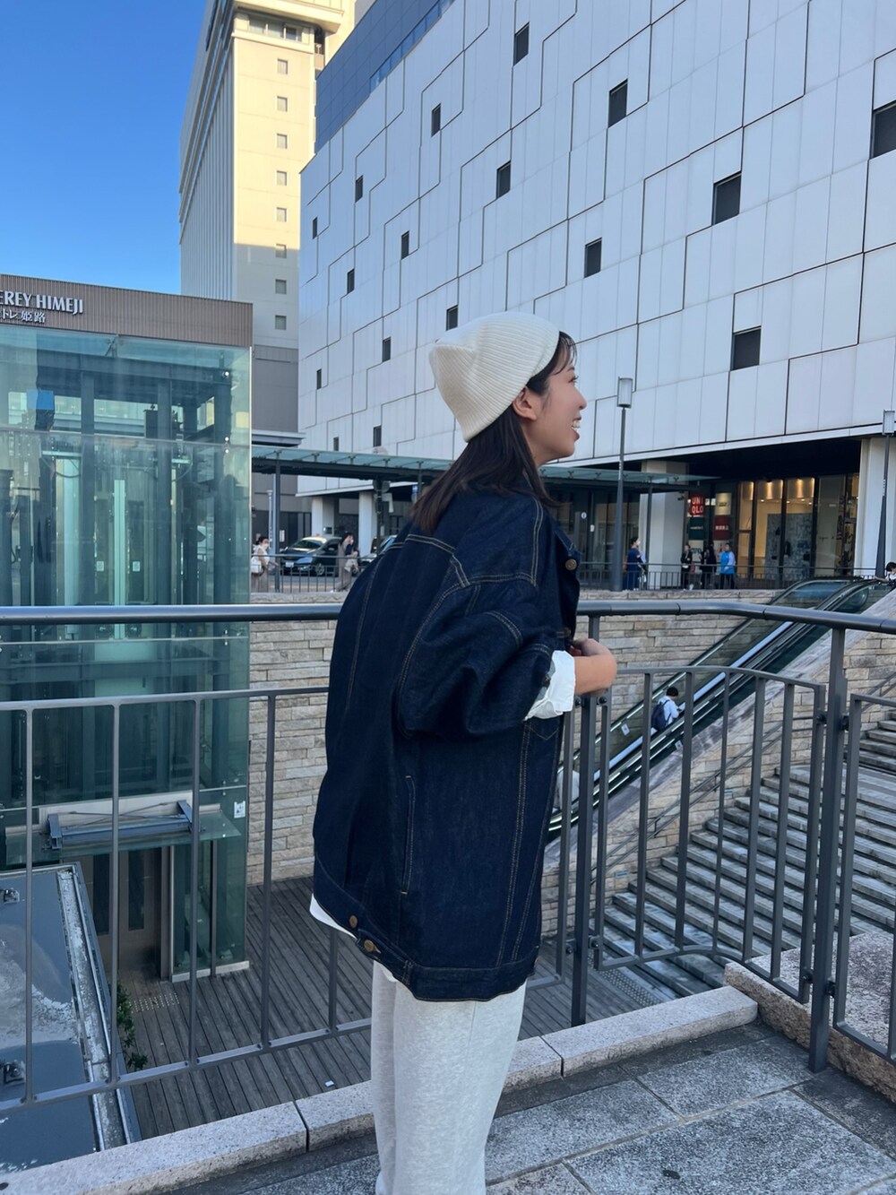 グレー系のスウェットパンツ、ブルー系のデニムジャケット、ブラック系のキャミソールを着用したレディースの秋コーディネートの6枚目の写真