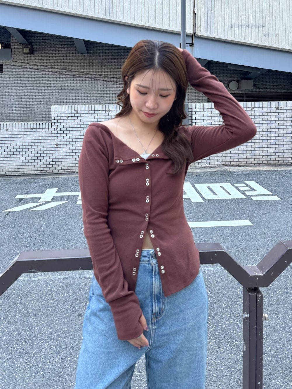 ブルー系のデニムパンツ、ブラウン系のTシャツ/カットソー、ブラウン系のブーツを着用したレディースの秋コーディネートの7枚目の写真