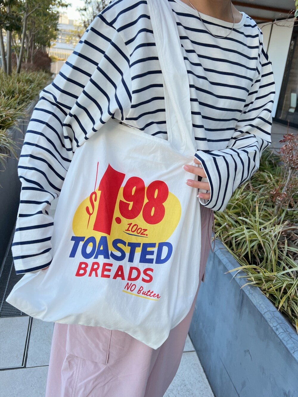 ピンク系のカーゴパンツ、ホワイト系のエコバッグ/サブバッグ、ブルー系のTシャツ/カットソーを着用したレディースの冬コーディネートの8枚目の写真