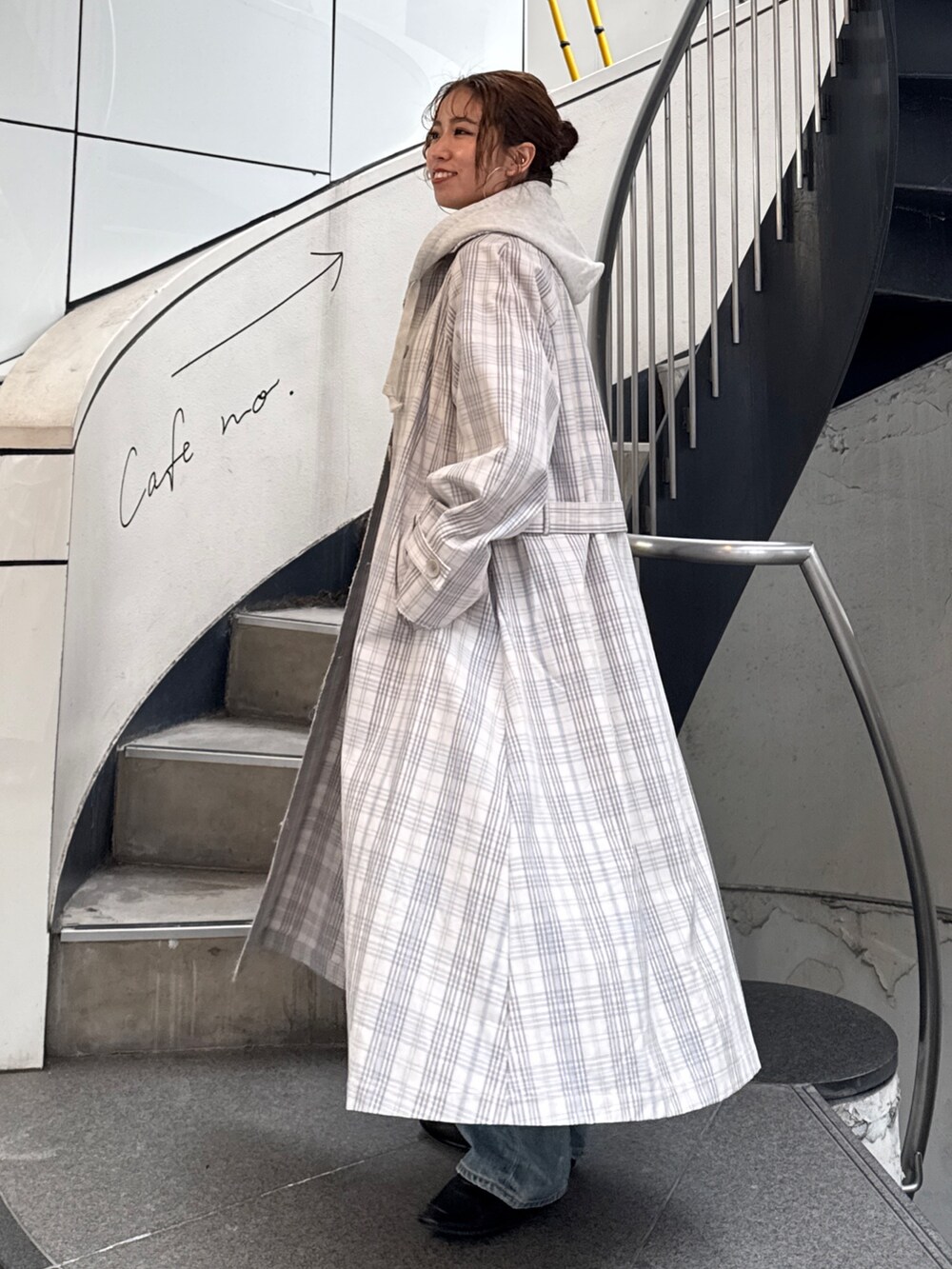 その他のステンカラーコート、ブラック系のボストンバッグ、ホワイト系のパーカーを着用したレディースの冬コーディネートの5枚目の写真