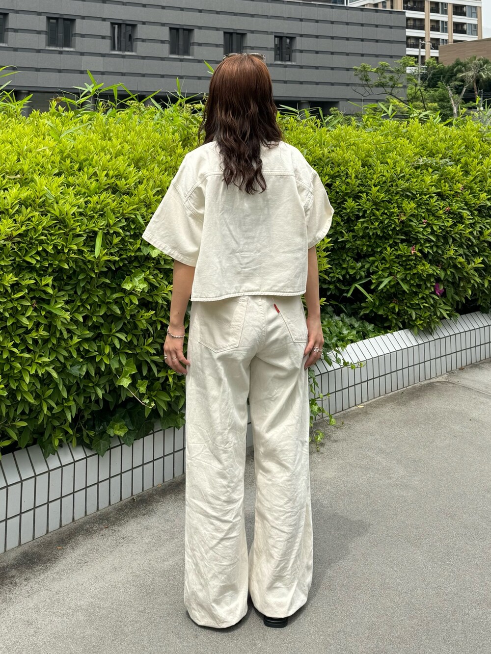 ホワイト系のシャツ/ブラウス、ホワイト系のデニムパンツ、グレー系のTシャツ/カットソーを着用したレディースの春コーディネートの6枚目の写真