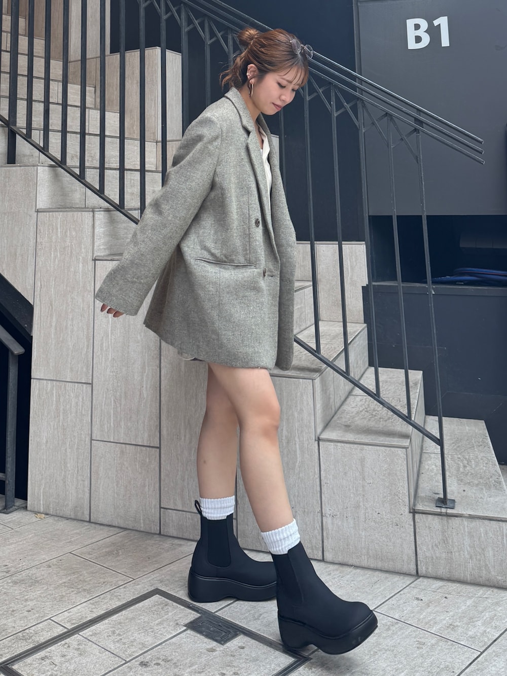 グレー系のスカート、ホワイト系のシャツ/ブラウス、グレー系のテーラードジャケットを着用したレディースの秋コーディネートの4枚目の写真