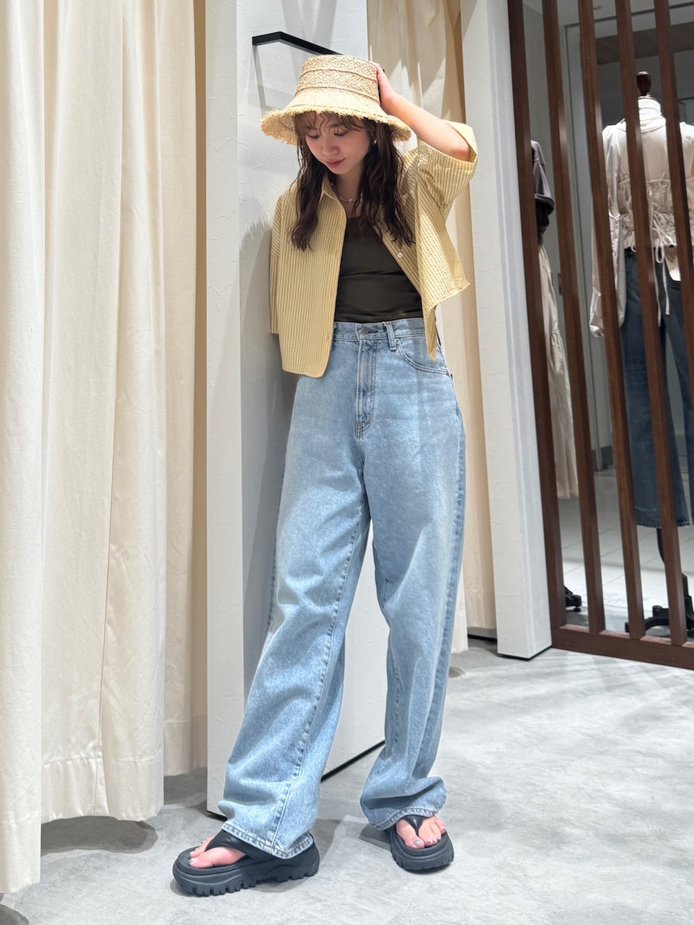 イエロー系のシャツ/ブラウス、ブルー系のデニムパンツ、ベージュ系のハットを着用したレディースの春コーディネートの5枚目の写真