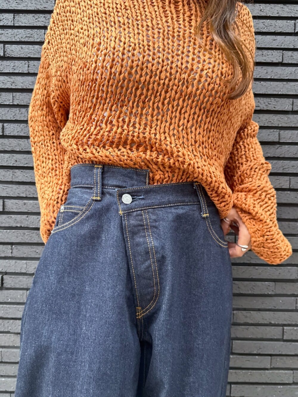 ホワイト系のその他シューズ、ブルー系のデニムパンツ、オレンジ系のニット/セーターを着用したレディースの夏コーディネートの6枚目の写真