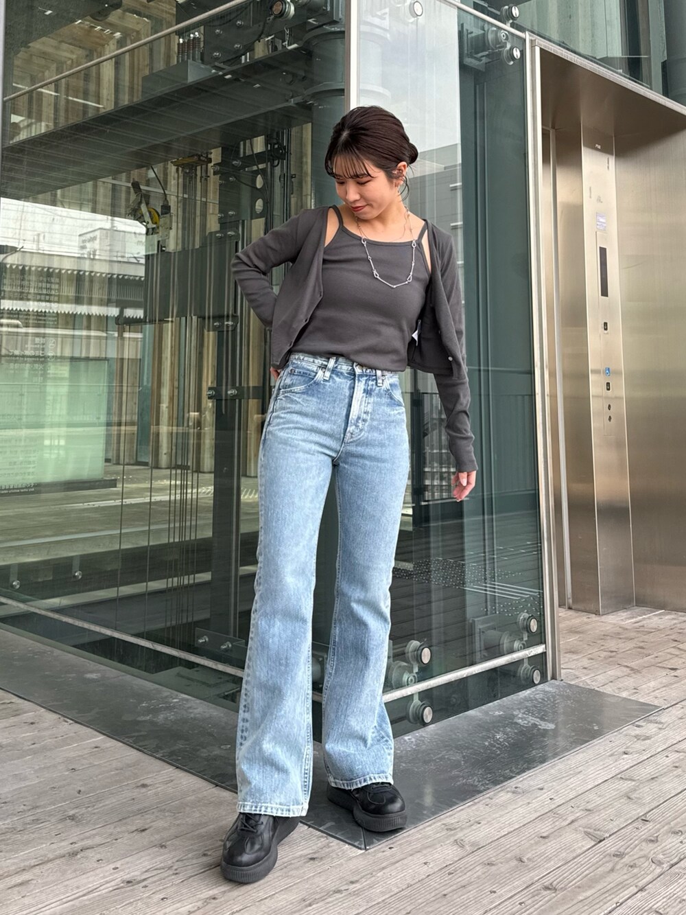 ブルー系のデニムパンツ、グレー系のTシャツ/カットソーを着用したレディースの春コーディネートの2枚目の写真