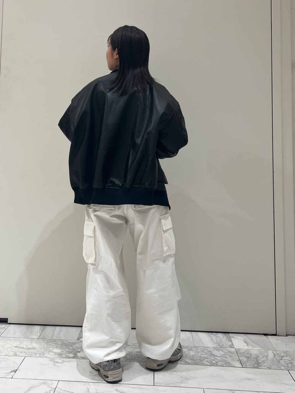 グレー系のニット/セーター、ホワイト系のカーゴパンツ、ブラック系のブルゾンを着用したレディースの秋コーディネートの7枚目の写真