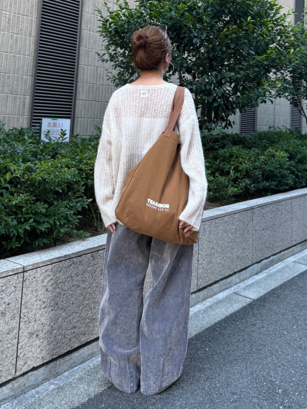 ベージュ系のデニムパンツ、ホワイト系のニット/セーター、ブラウン系のトートバッグを着用したレディースの夏コーディネートの5枚目の写真