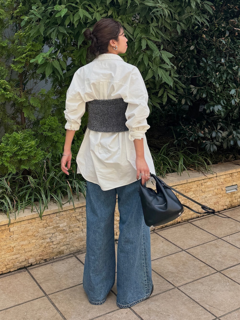 ブルー系のデニムパンツ、ホワイト系のシャツ/ブラウス、ブラック系のニット/セーターを着用したレディースの秋コーディネートの5枚目の写真