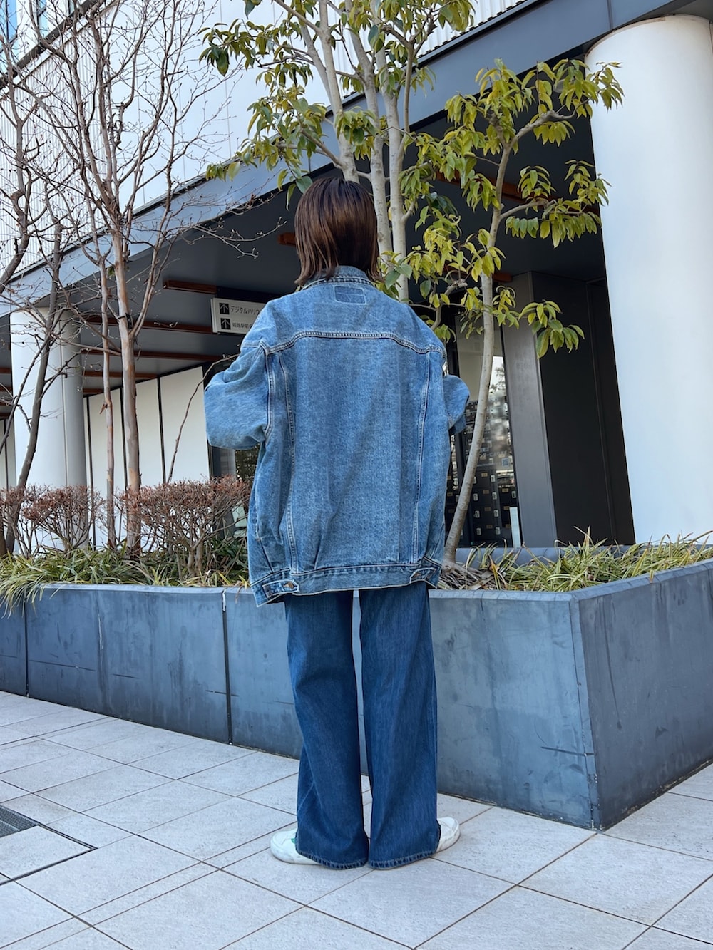 ブルー系のデニムパンツ、ホワイト系のハンドバッグ、ブルー系のデニムジャケットを着用したレディースの冬コーディネートの6枚目の写真