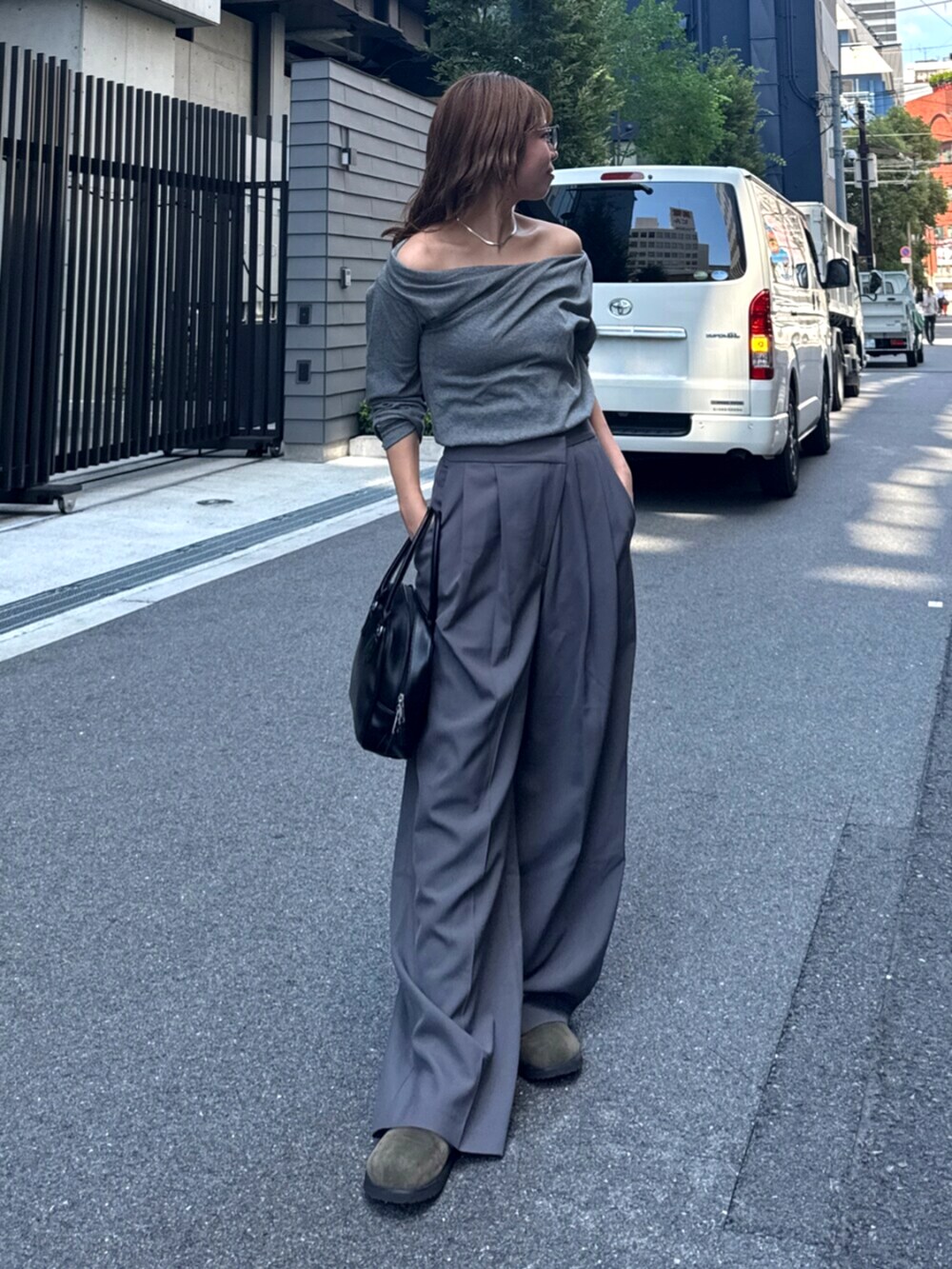 グレー系のその他パンツ、ベージュ系のスリッポン、ブラック系のハンドバッグを着用したレディースの夏コーディネートの3枚目の写真