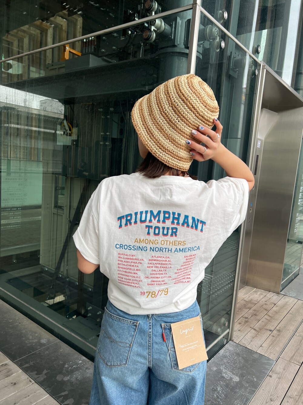 ホワイト系のTシャツ/カットソー、ホワイト系のサンダル、ブルー系のデニムパンツを着用したレディースの春コーディネートの7枚目の写真
