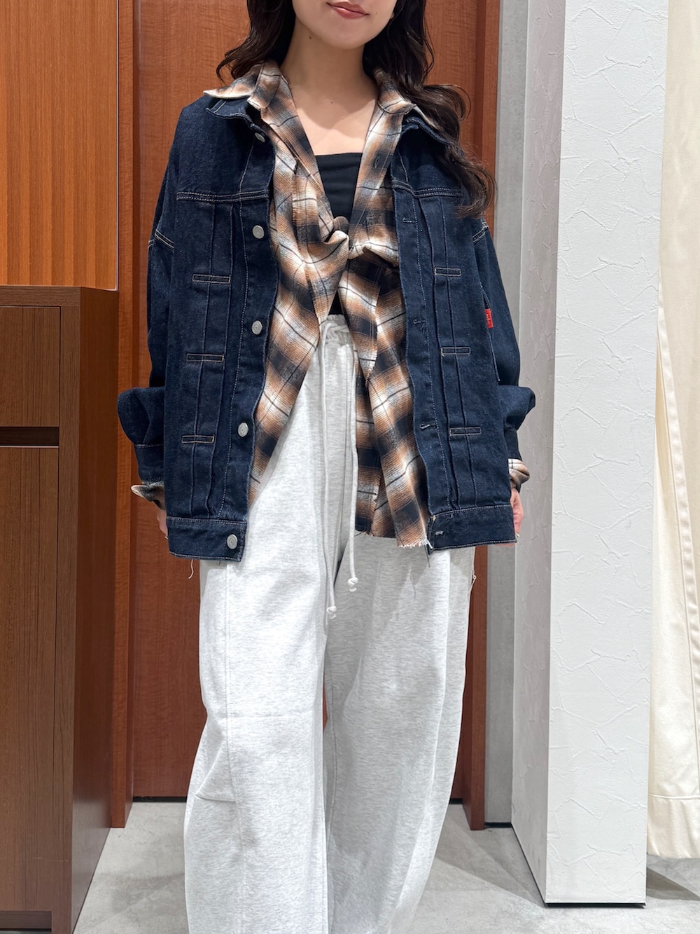 ブラウン系のシャツ/ブラウス、ブルー系のデニムジャケット、グレー系のスウェットパンツを着用したレディースの秋コーディネートの6枚目の写真