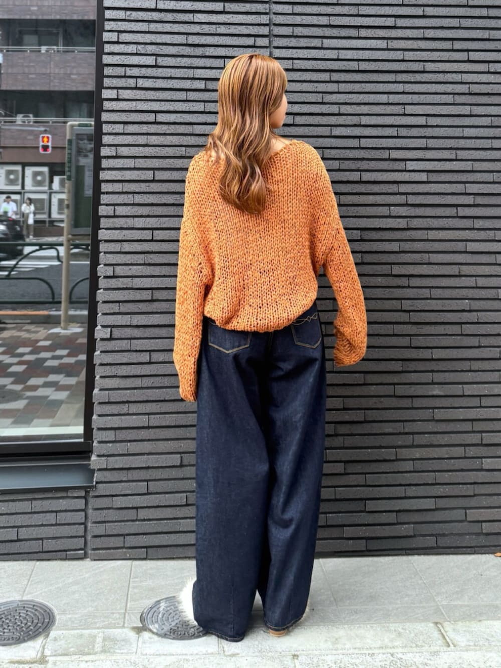 ホワイト系のその他シューズ、ブルー系のデニムパンツ、オレンジ系のニット/セーターを着用したレディースの夏コーディネートの4枚目の写真