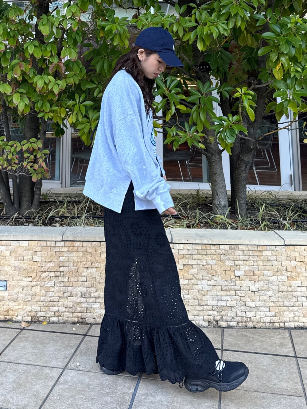 ブラック系のスカート、グレー系のスウェット、ブラック系のスニーカーを着用したレディースの冬コーディネートの3枚目の写真