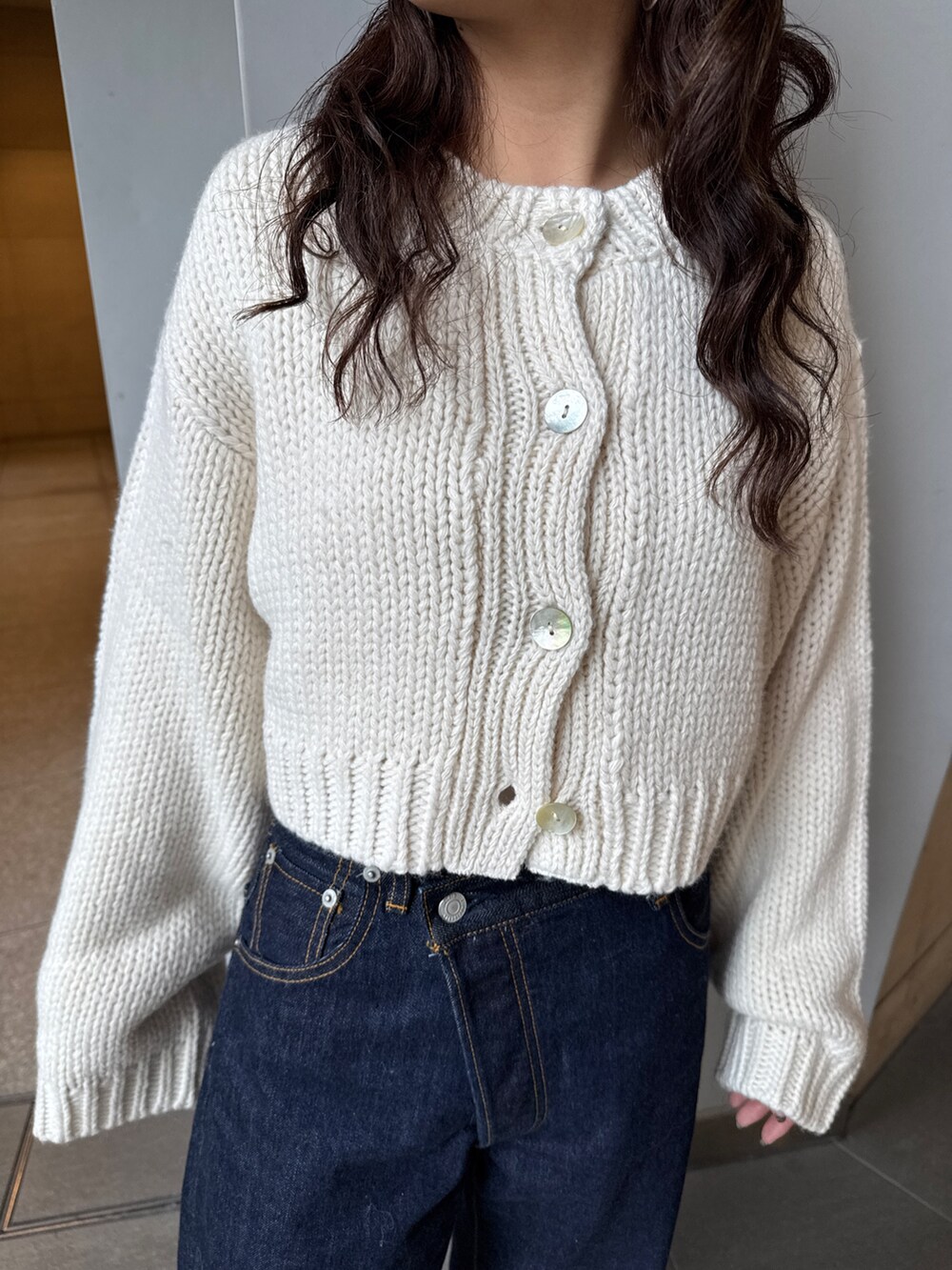 ホワイト系のTシャツ/カットソー、ホワイト系のカーディガン/ボレロ、ブルー系のデニムパンツを着用したレディースの冬コーディネートの10枚目の写真