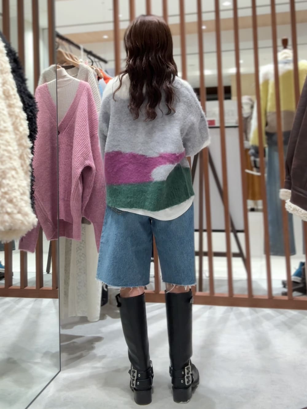 グリーン系のニット/セーター、ホワイト系のTシャツ/カットソー、ブルー系のデニムパンツを着用したレディースの秋コーディネートの6枚目の写真