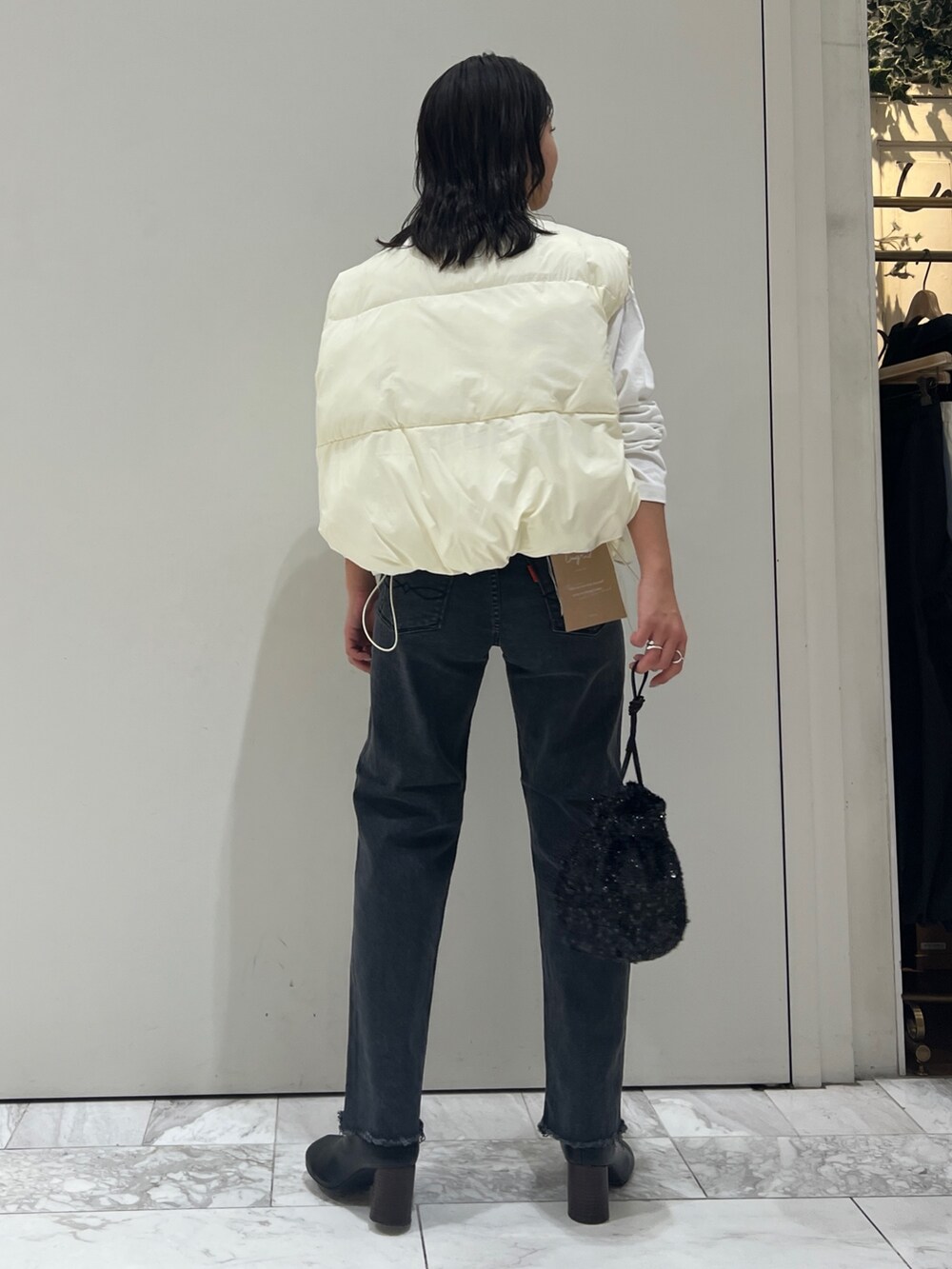 ブラック系のブーツ、ホワイト系のTシャツ/カットソー、ブラック系のデニムパンツを着用したレディースの秋コーディネートの6枚目の写真